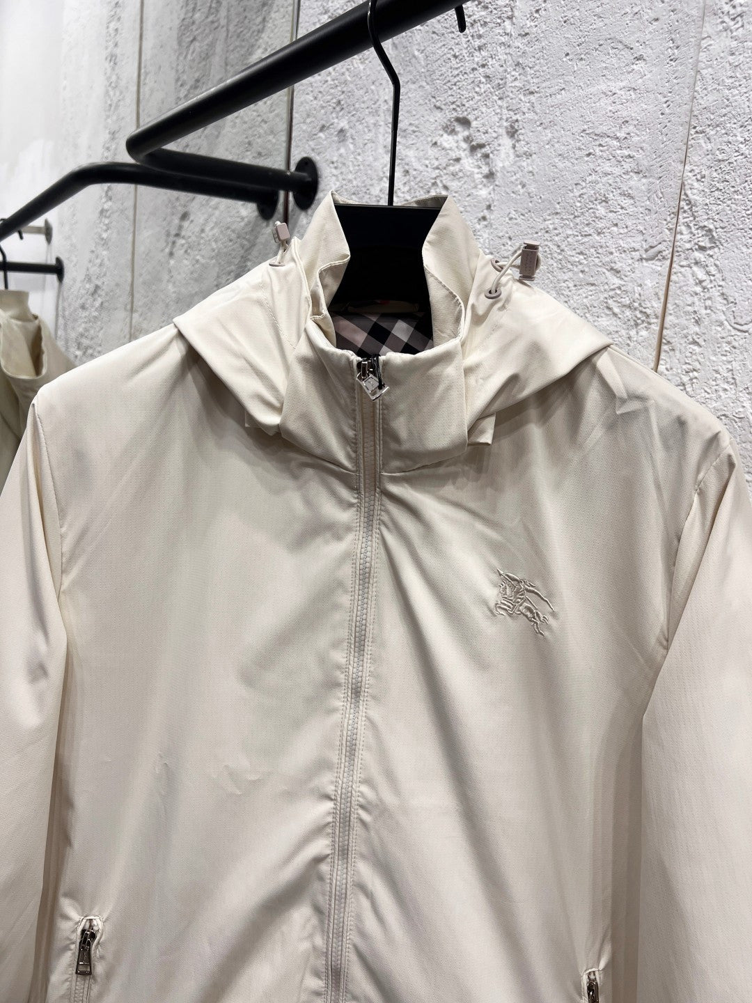 White hooded jacket front with stand collar, full zipper, and small chest logo