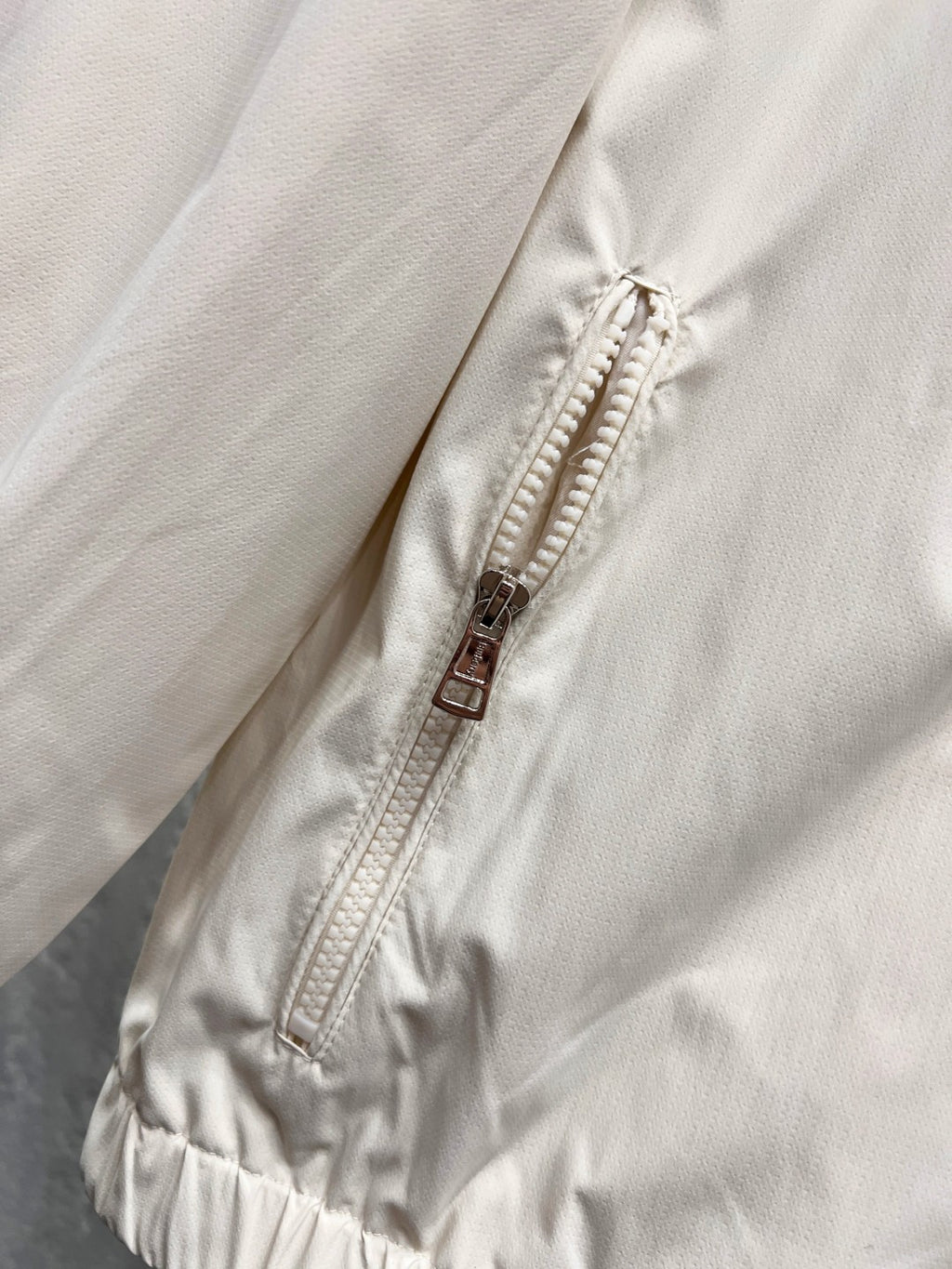 White jacket with exposed front zipper and stitched placket close-up