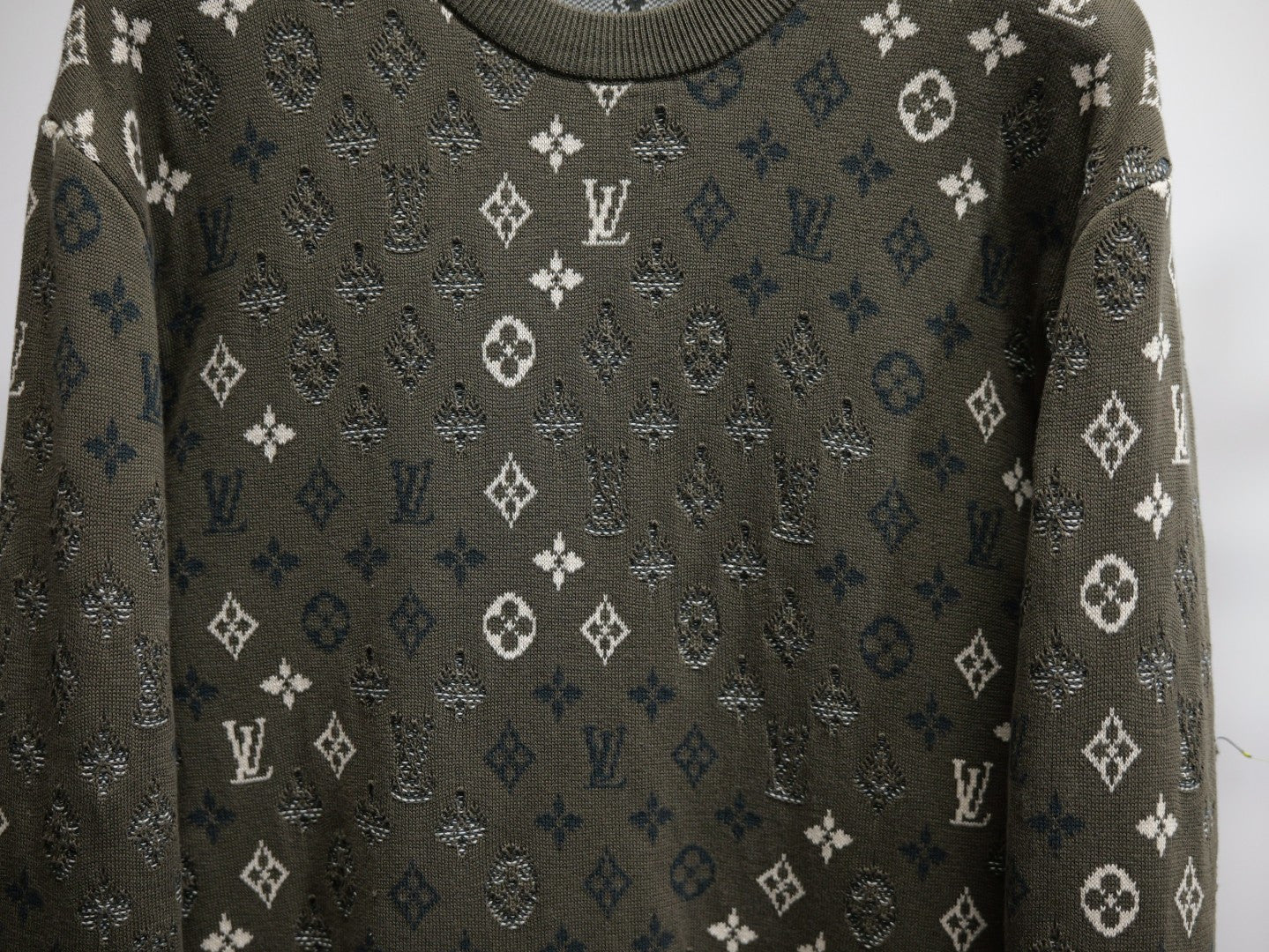Louis Vuitton monogram long-sleeve sweatshirt close-up, dark olive with scattered white icons