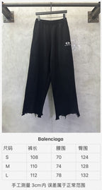 Balenciaga black wide-leg pants with elastic waist and frayed hem
