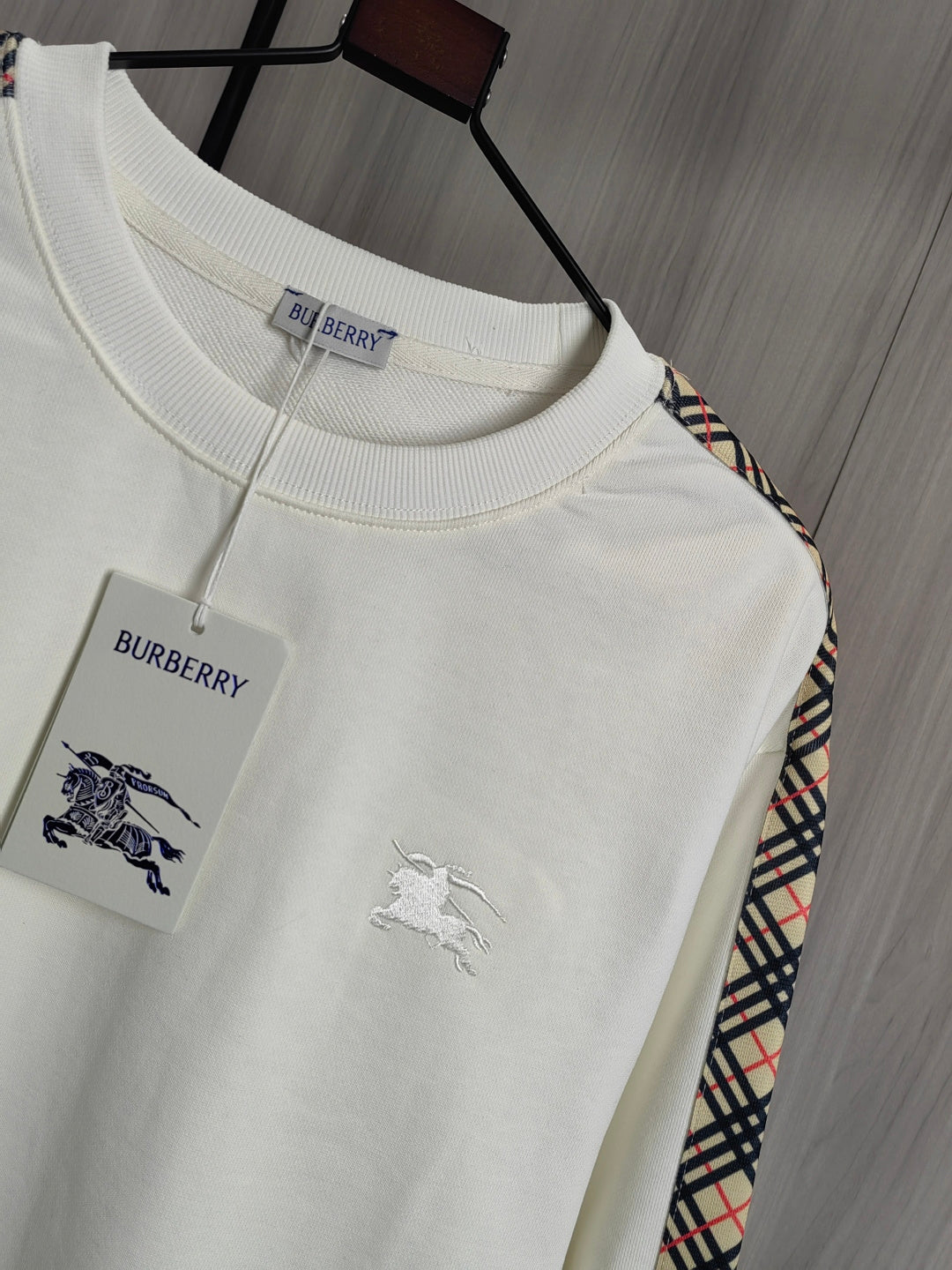 Burberry kids crewneck sweatshirt close-up with crew neck, chest graphics, and tag.