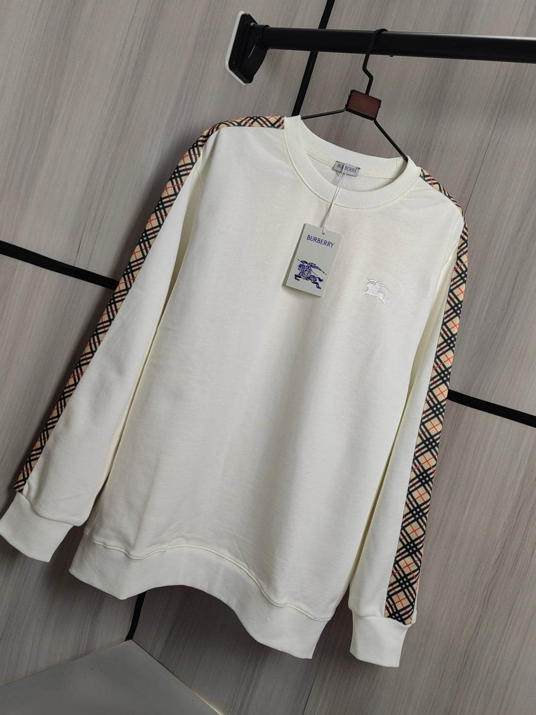 Burberry kids crewneck sweatshirt in cream with check-trim sleeves and front chest motifs.