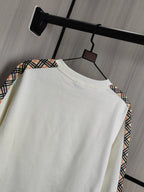 Burberry kids crewneck sweatshirt side view in cream with check trim at shoulder.
