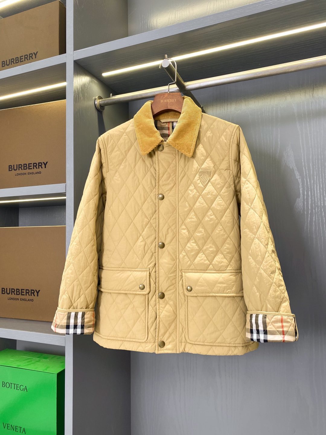 Light quilted jacket with button front, stand collar, and plaid cuff trim
