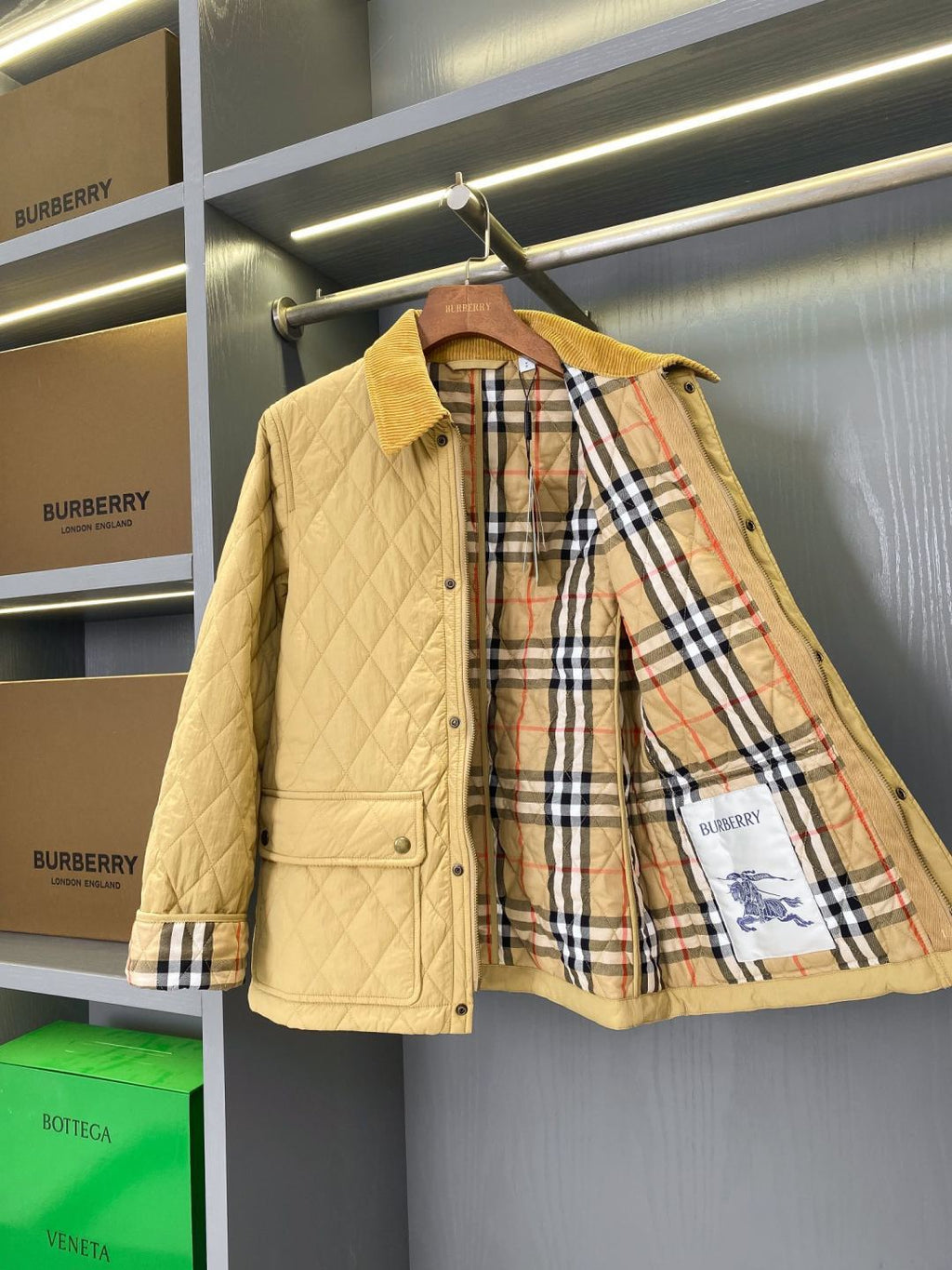 Light quilted jacket with plaid lining visible and button front, stand collar