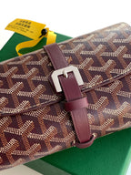 Goyard monogram canvas bag close-up with rectangular buckle and burgundy strap