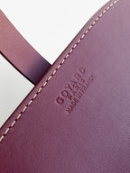 Goyard embossed on burgundy leather with cream contrast stitching