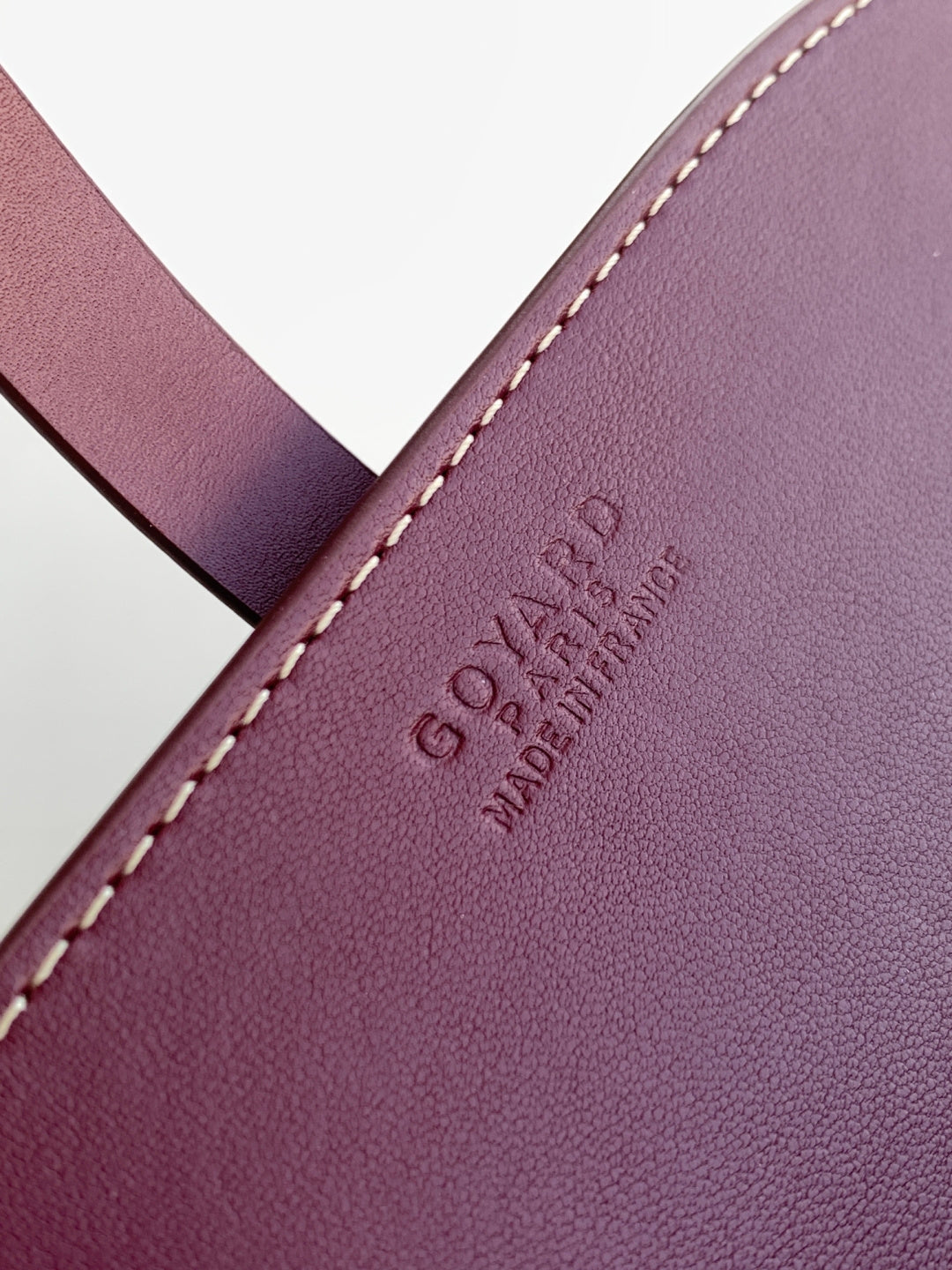 Goyard embossed on burgundy leather with cream contrast stitching