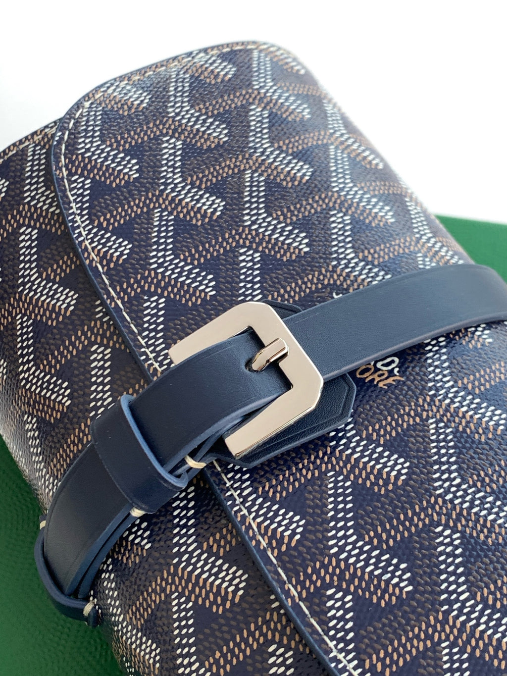 Goyard monogram bag with navy leather buckle strap and metal clasp