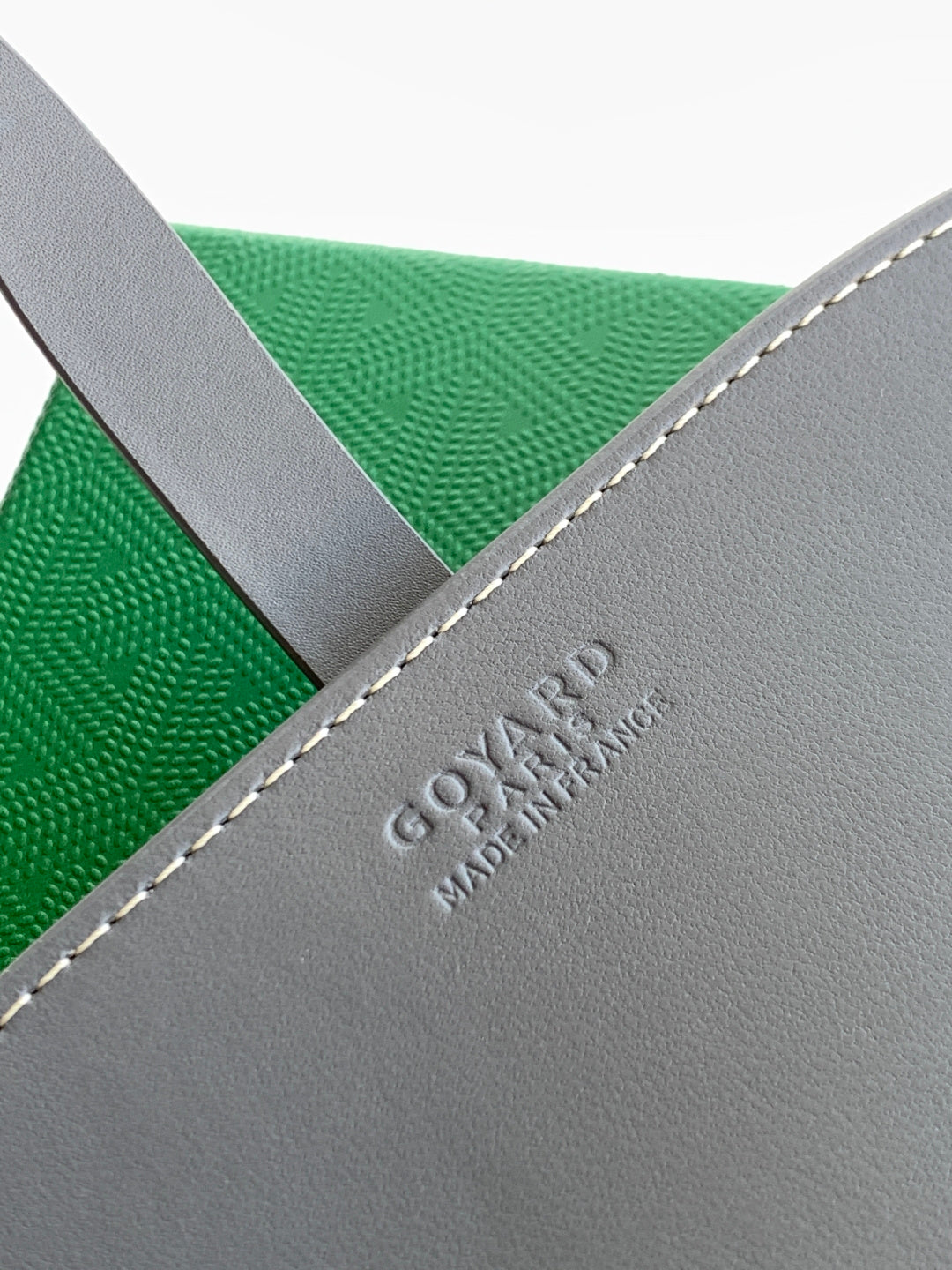 Goyard bag exterior corner with embossed logo and gray leather trim