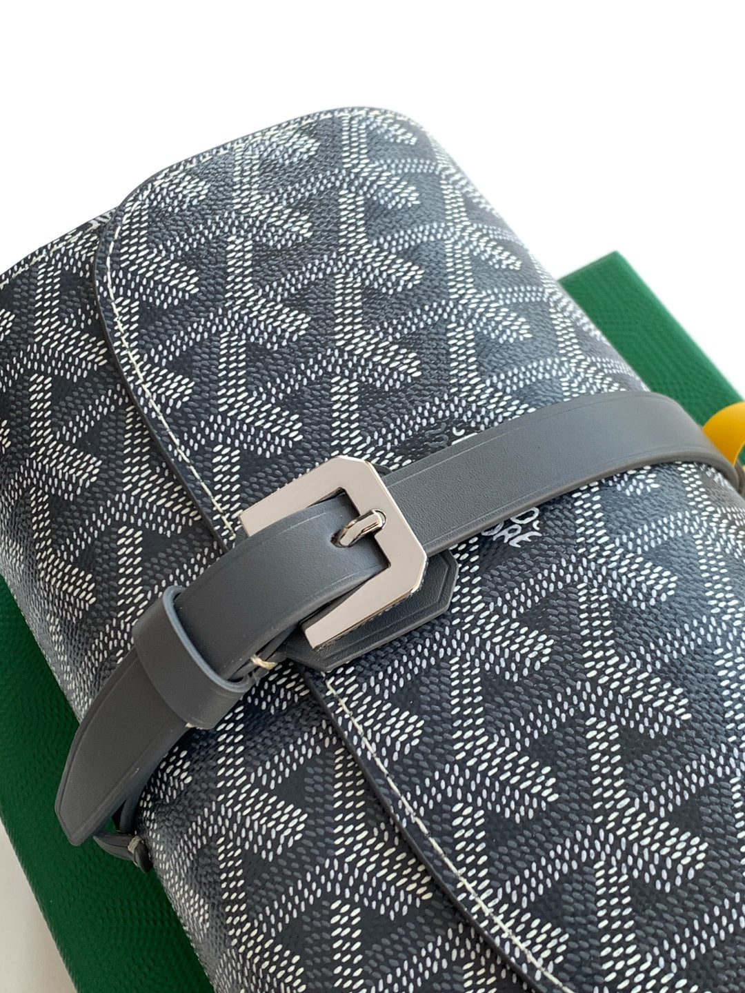 Goyard patterned bag detail with gray buckle hardware and monogram canvas