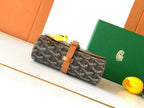 Goyard bag on display: dark monogram canvas with tan leather belt strap