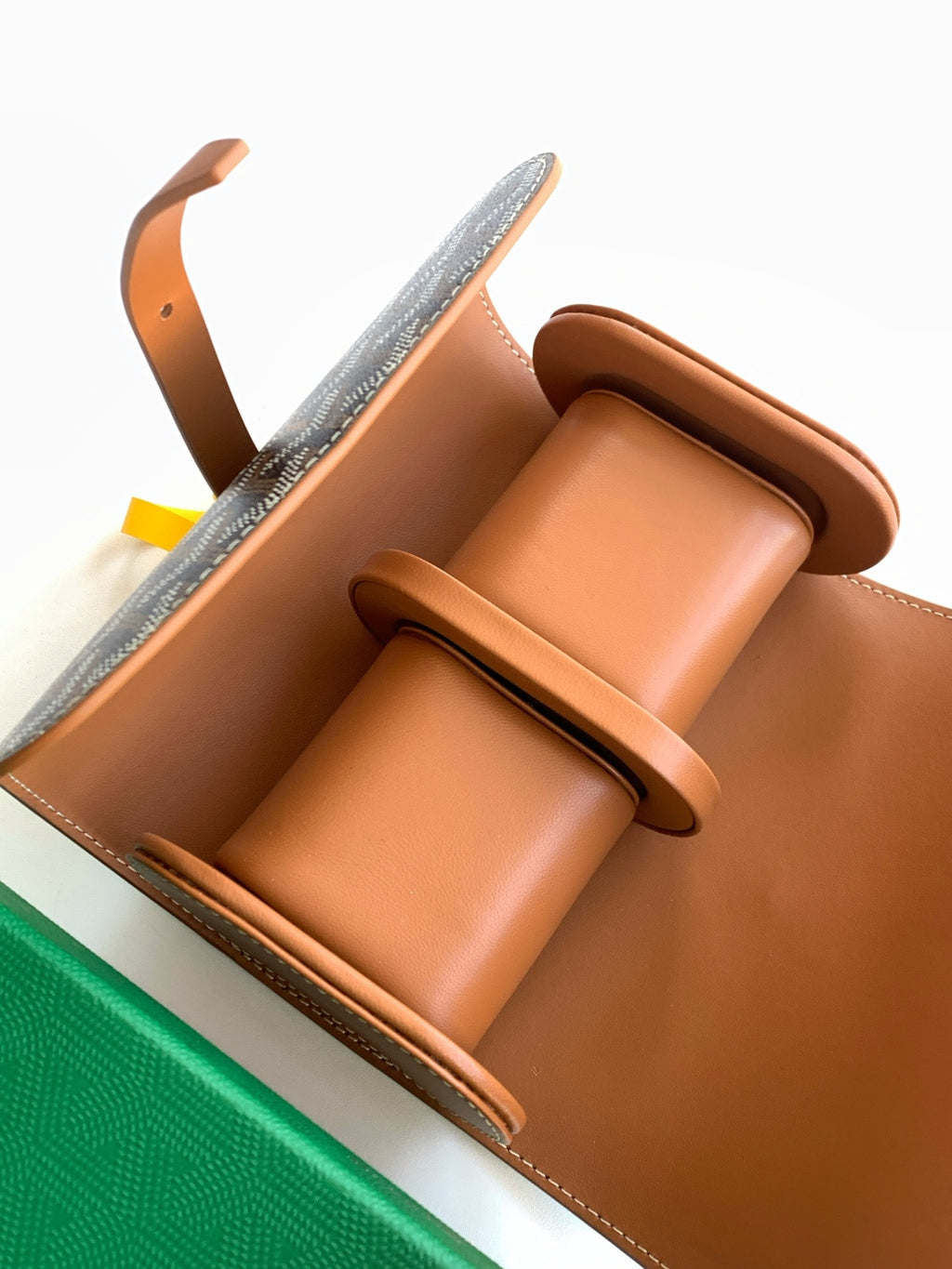Goyard bag interior view: tan leather compartments with dark monogram canvas trim