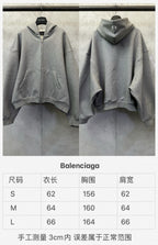 Balenciaga gray zip and pullover hoodies shown side by side on hangers.
