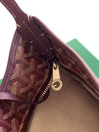 Open monogram bag showing lined interior and zip with leather pull tab