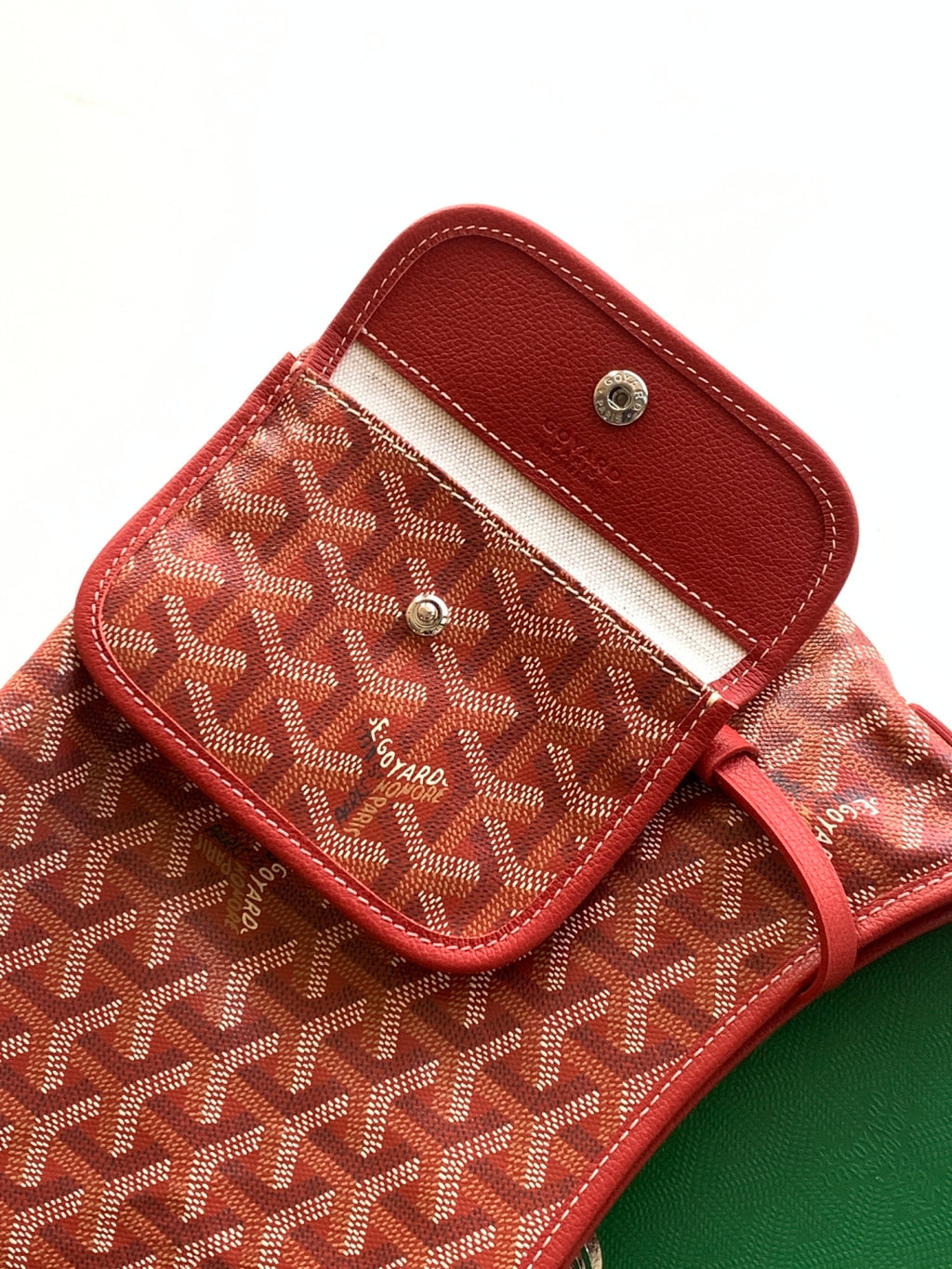 Goyard hobo bag flap pocket close-up with snap button and red leather trim