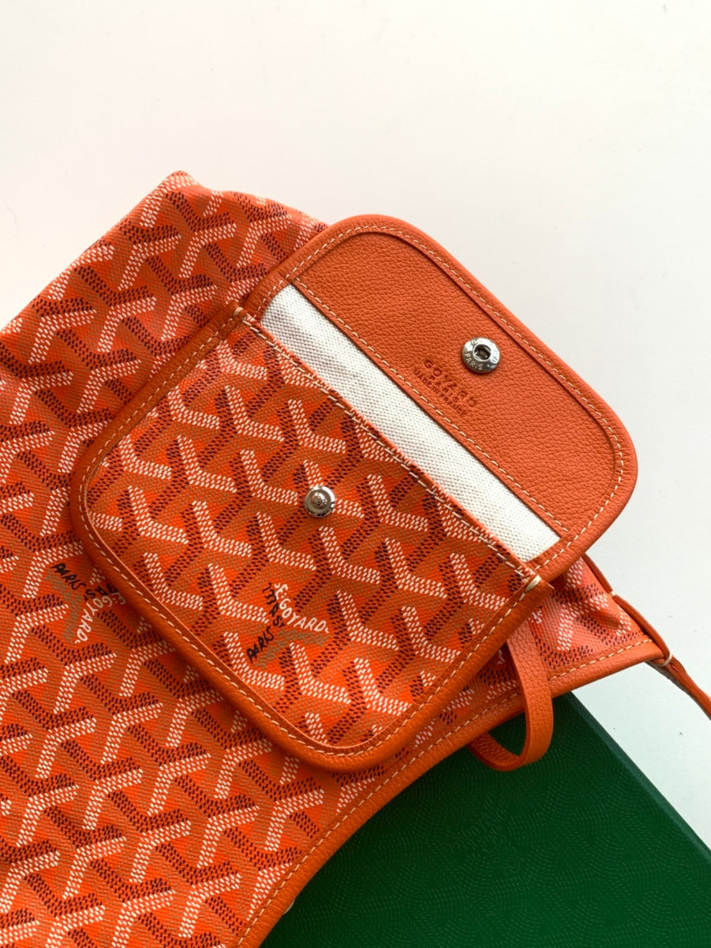 Goyard patterned shoulder bag section with leather tab and metal snap details