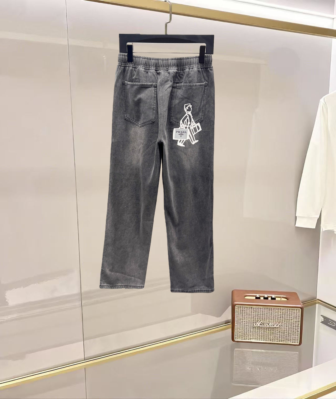 Dark gray denim pants with elastic waistband and white graphic logo on leg