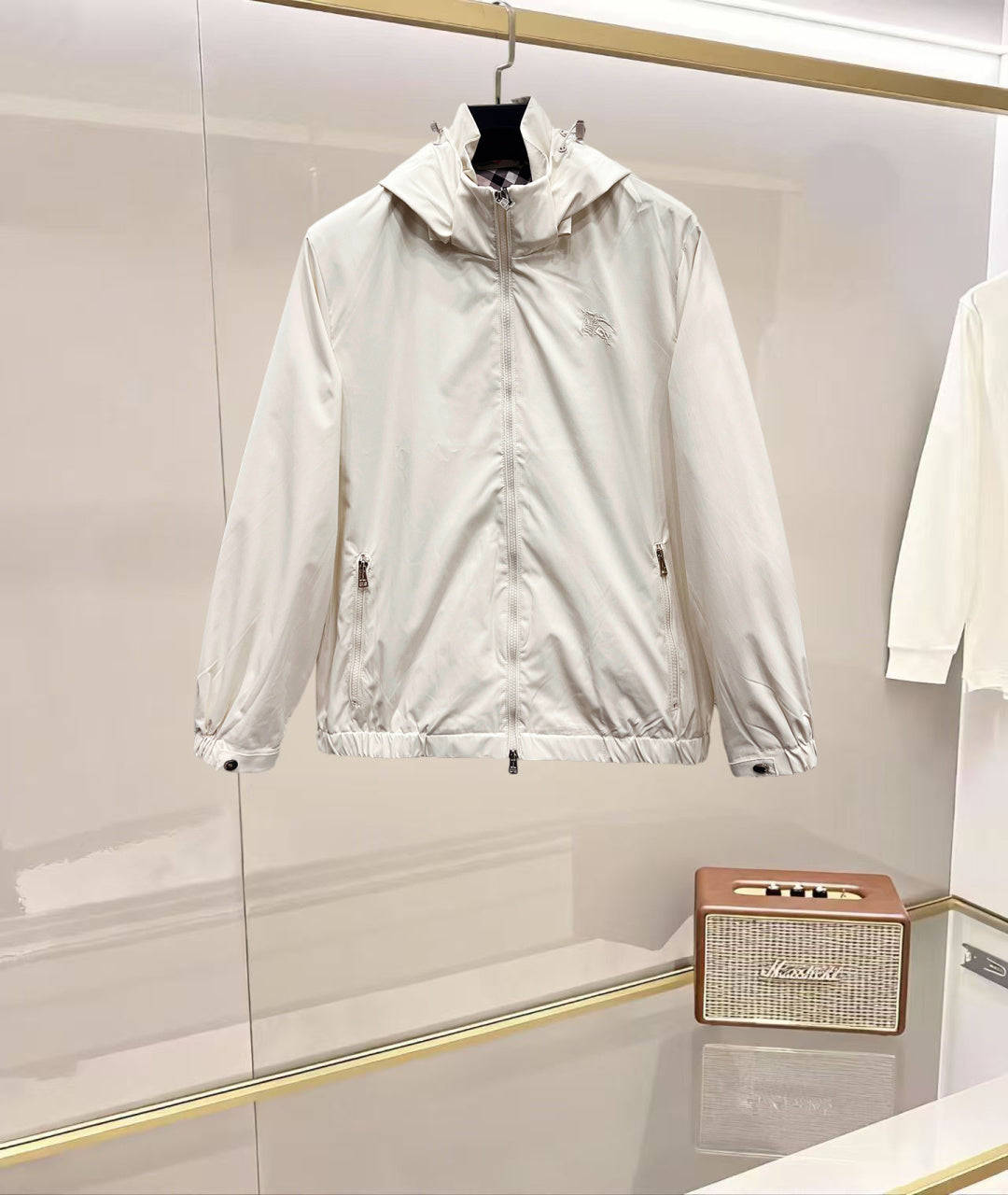 Light hooded jacket in white with front zipper and snap pockets, drawcord waist hem