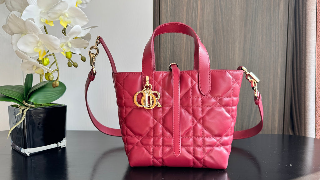 Pink quilted Dior tote bag with top handle and crossbody strap, gold-tone clasp front