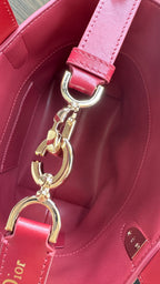 Pink Dior tote bag with gold keyring charm and logo hardware on side