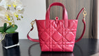 Pink quilted Dior tote bag with top handle and long side strap, angled front view