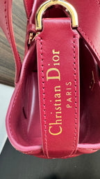 Pink Dior tote bag with gold top handle hardware and interior logo patch