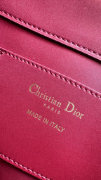 Pink Dior bag leather logo patch with decorative stitching and text detailing