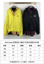 Two zip-up hooded jackets on hangers: yellow and black with plaid inner layer