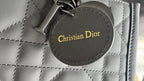 Christian Dior round logo patch on quilted bag, with stitched border on dark leather