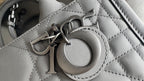 Dior hardware clasp on quilted leather bag, dark metal ring and engraved details