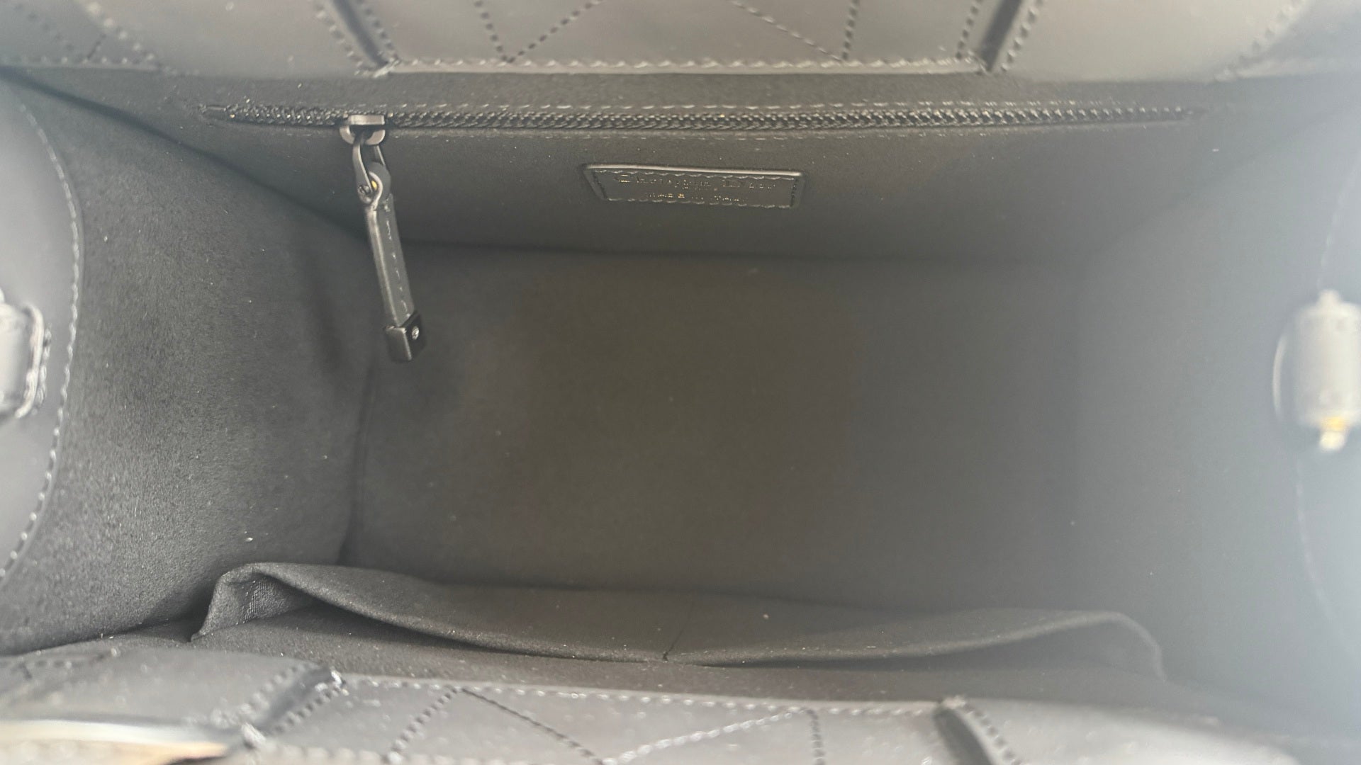 Interior of Dior leather pouch with side seams and zip pocket panel