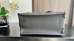 Dior leather clutch pouch with structured shape and top zipper edge, dark leather