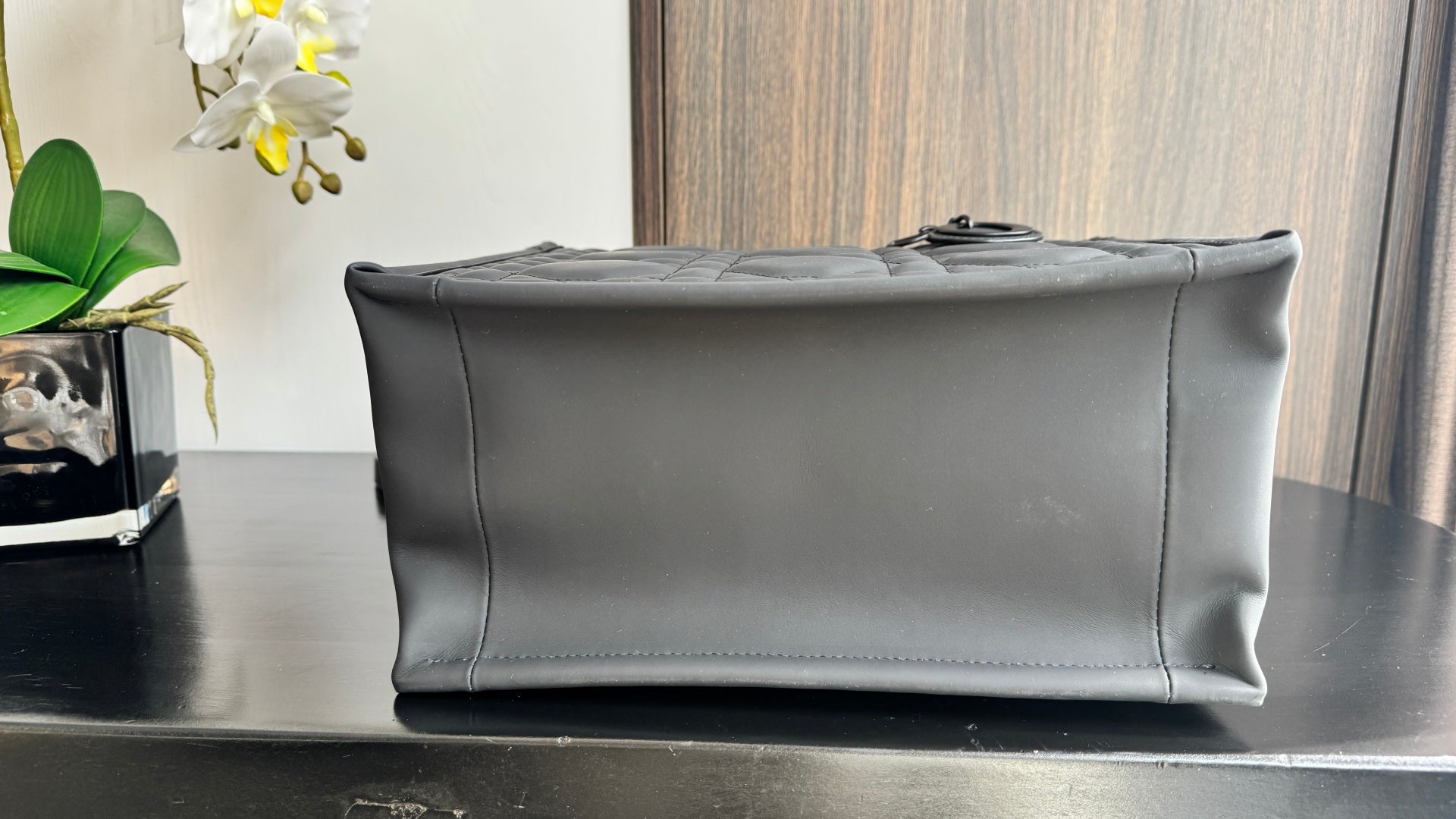 Dior leather clutch pouch with structured shape and top zipper edge, dark leather