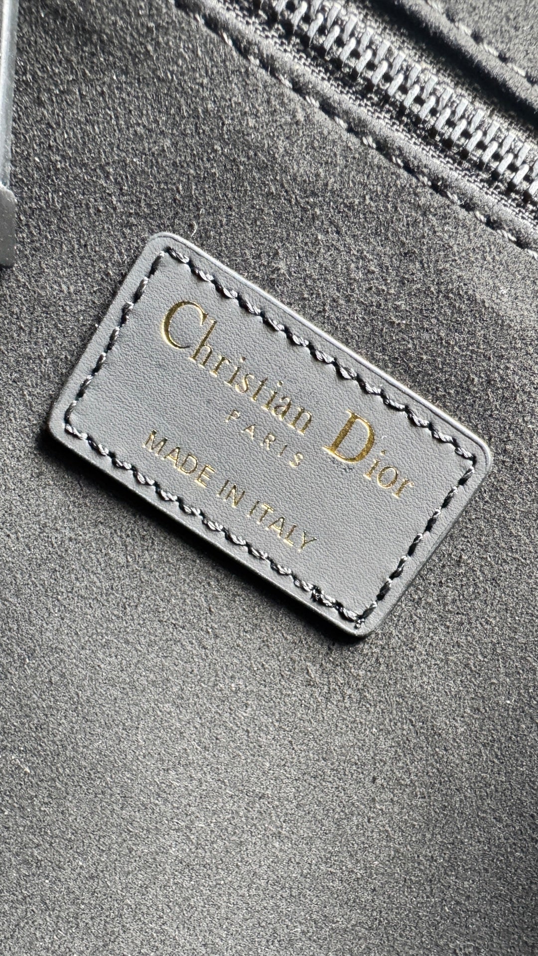 Christian Dior label on dark fabric: Made in Italy, stitched onto bag lining