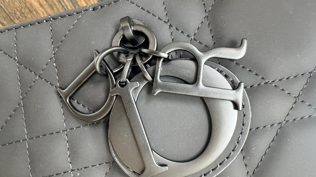 Dior bag strap clasp and ring hardware on quilted dark gray leather