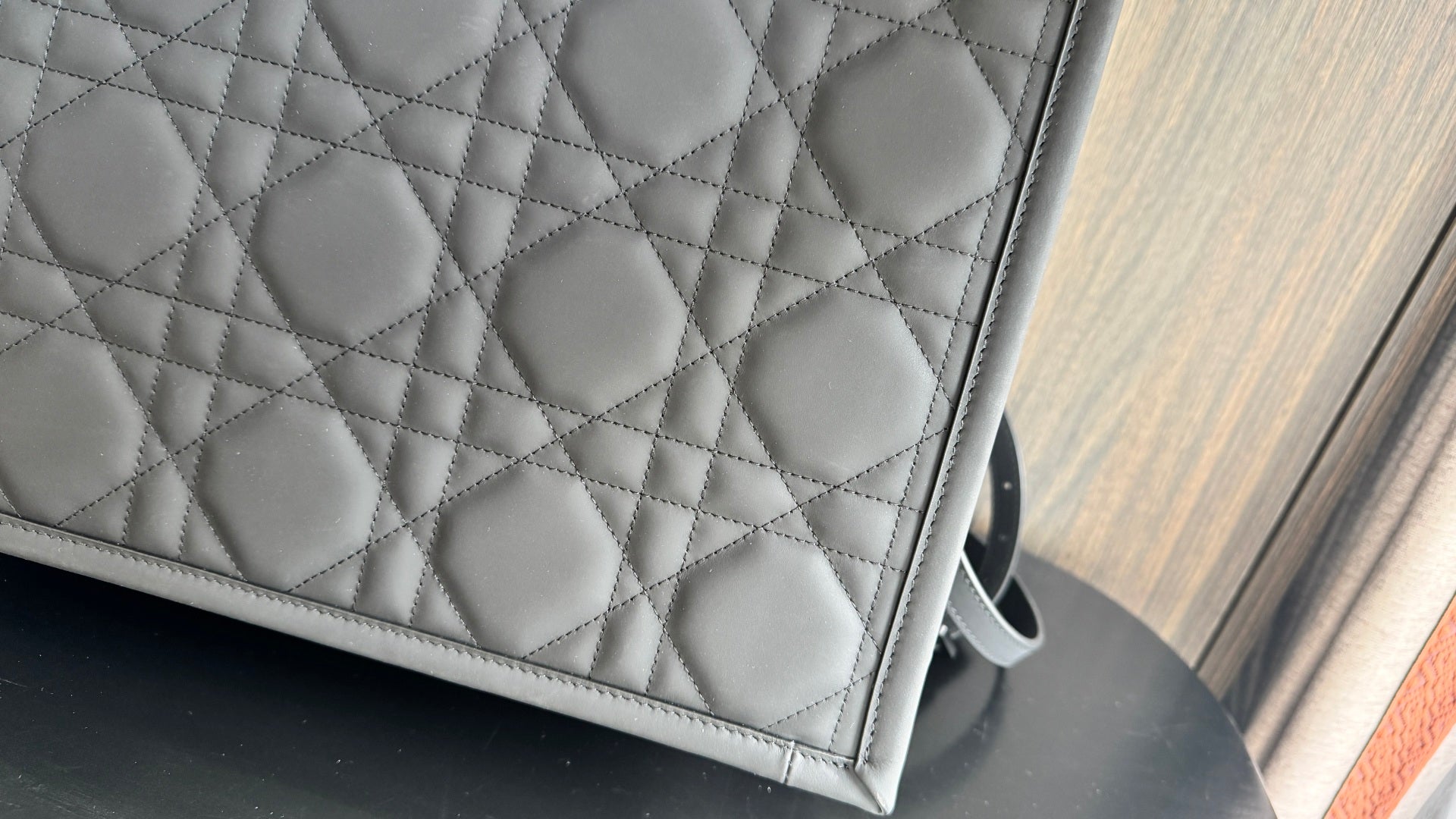 Dior quilted tote bag panel with repeating diamond pattern, dark gray leather