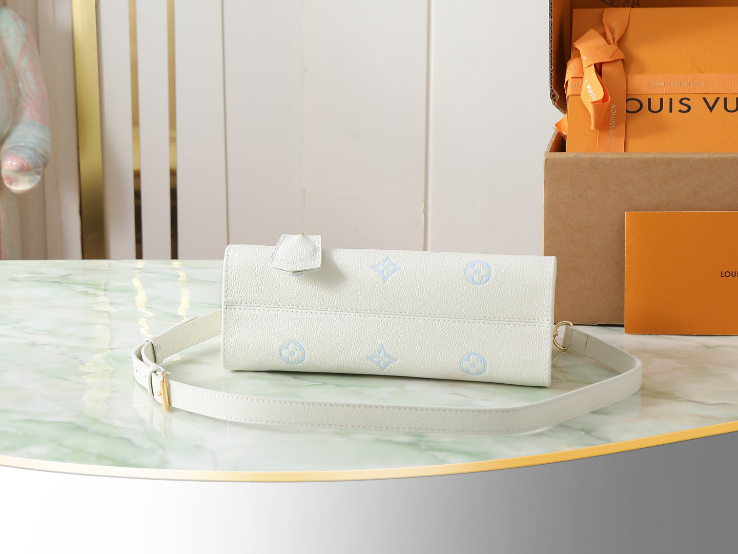 Louis Vuitton envelope clutch in white pebbled leather with light blue motifs and shoulder strap