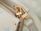 Louis Vuitton bag clasp detail with gold hardware on white leather strap