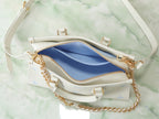 Louis Vuitton bag open view with white exterior, blue fabric lining, and gold hardware