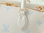 Louis Vuitton bag detail: white leather strap loop with light blue monogram pattern