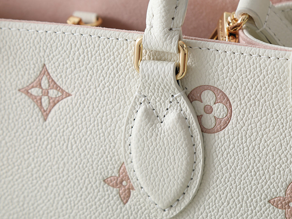 Louis Vuitton bag leather close-up with monogram charm and white strap attachment