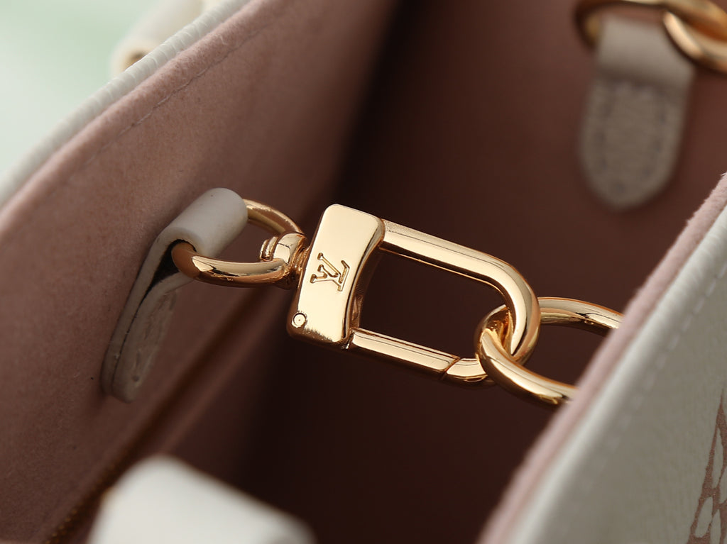 Louis Vuitton bag detail with gold-tone turn-lock clasp and pink interior lining