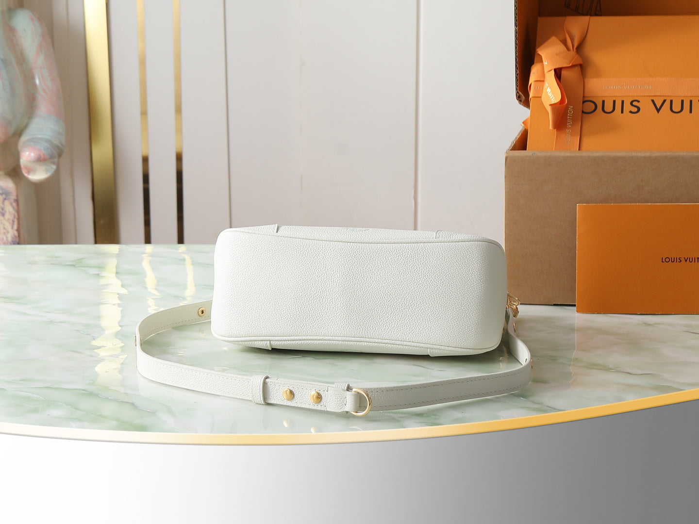 White small flap bag with gold clasp and adjustable strap