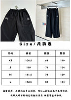 Black Balenciaga track pants, elastic waistband and straight wide-leg silhouette