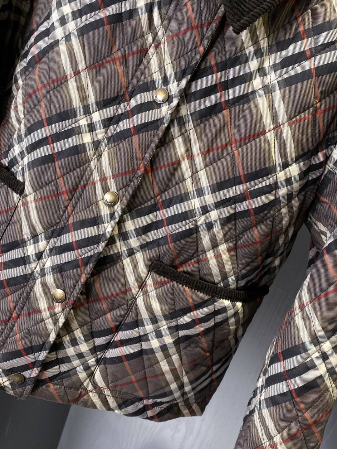 Burberry quilted plaid jacket close-up with metal buttons and drawstring hem