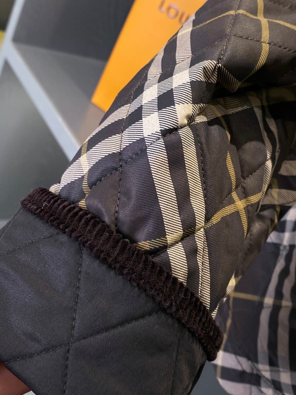 Burberry plaid jacket cuff with dark elastic trim and quilted fabric detail