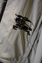 Close-up of black horse logo patch on light plaid fabric