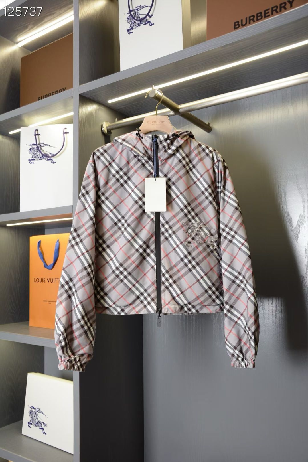 Hoodless plaid jacket with front zipper and small horse logo on the back