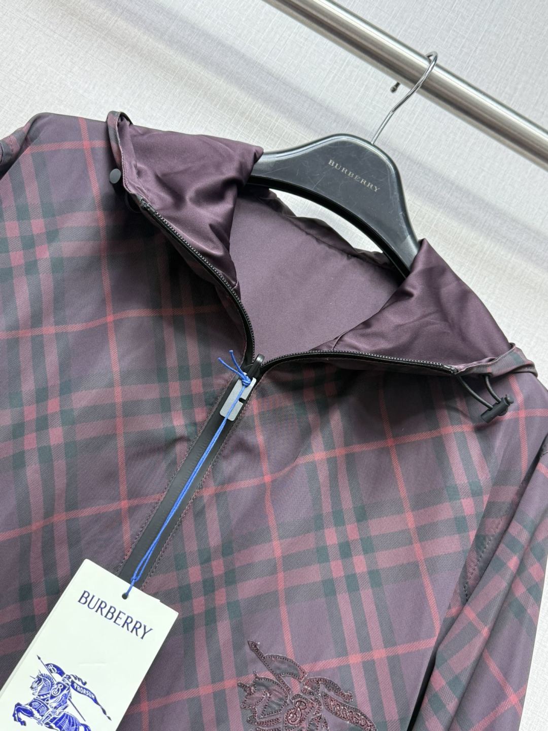 Burberry plaid hooded jacket with zip front and interior lining detail at chest.
